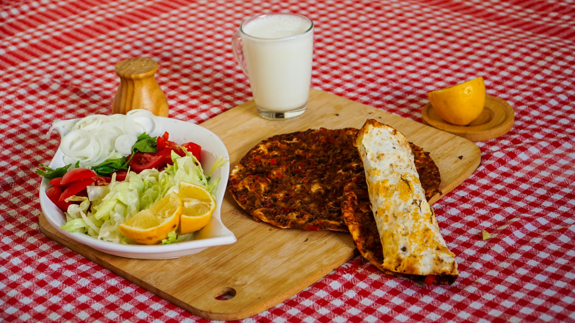 Repas complet avec lahmacun, salade fraîche et un verre d'ayran traditionnel.