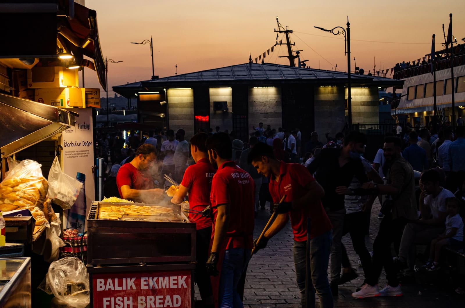 Cuisson de sandwichs au poisson balik ekmek au crépuscule à Istanbul.