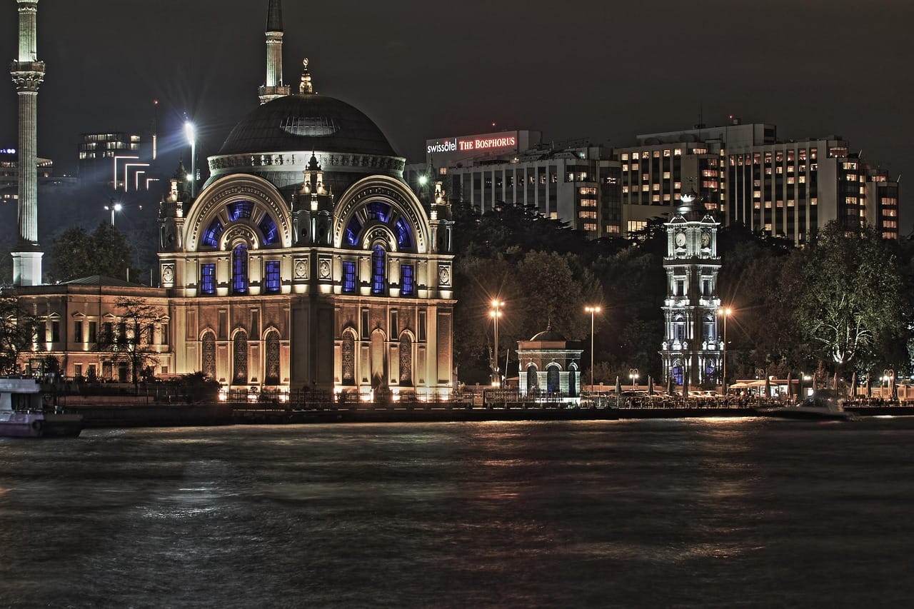 La mosquée de Dolmabahçe et la tour de l'horloge illuminées de nuit.