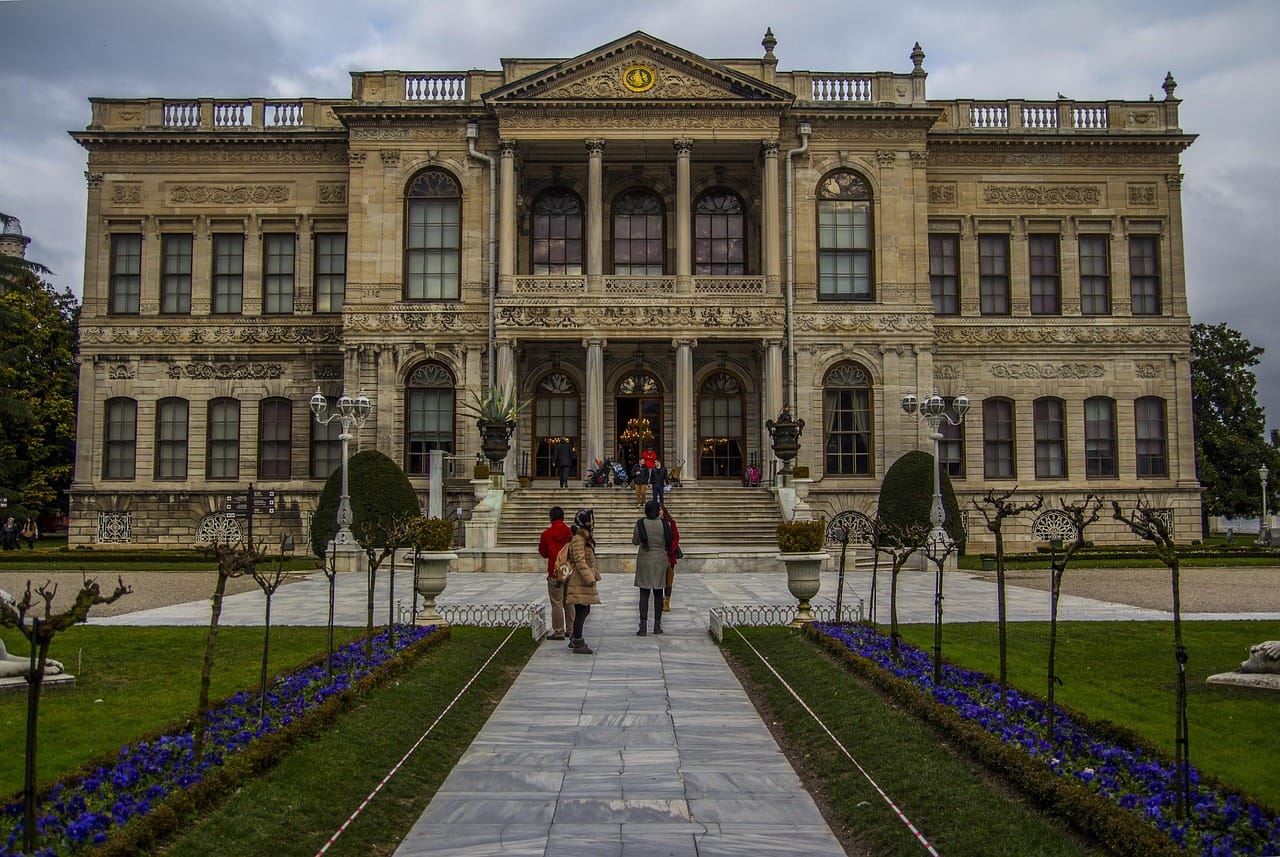 Visiteurs devant l'entrée et les jardins du palais de Dolmabahçe.