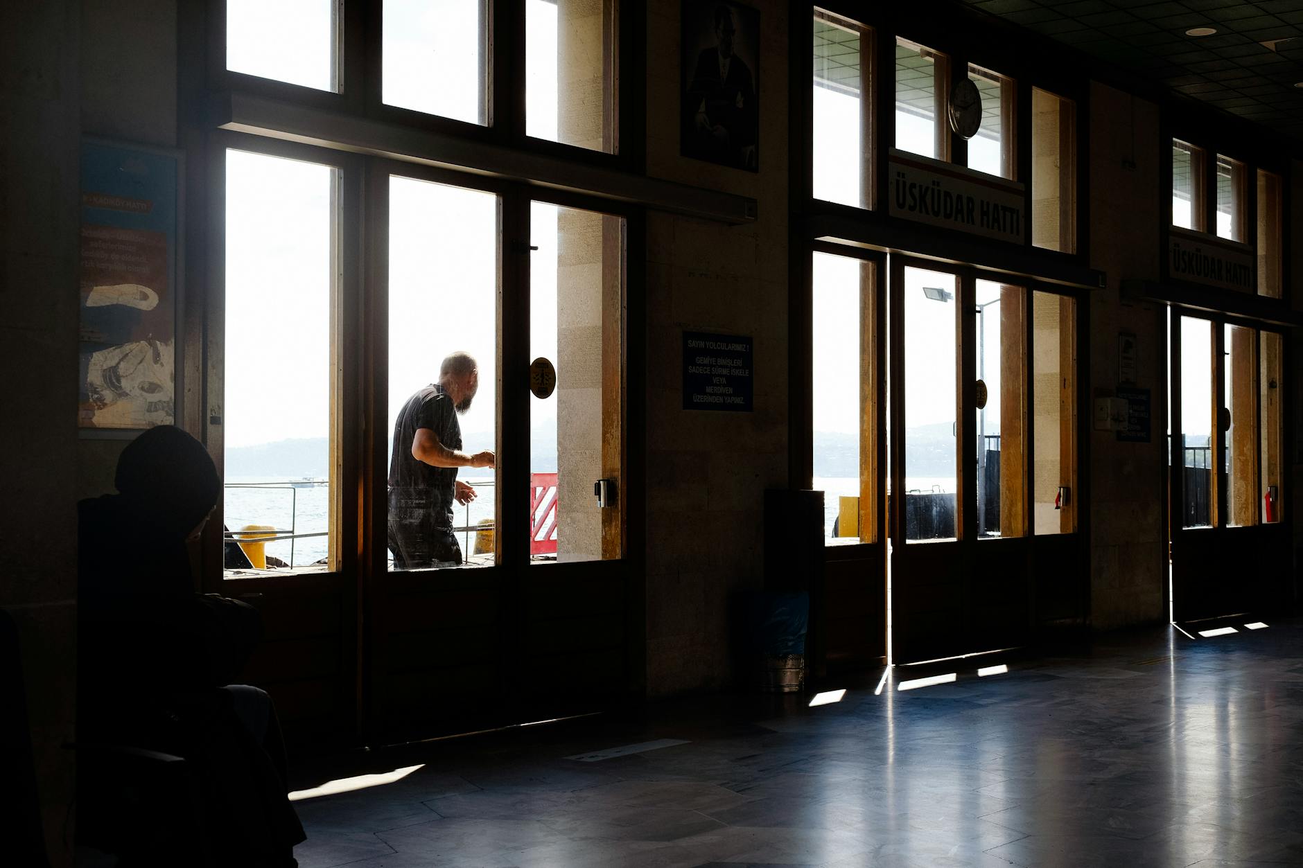 Passagers attendant la traversée vers Üsküdar à l'intérieur d'une gare maritime lumineuse.