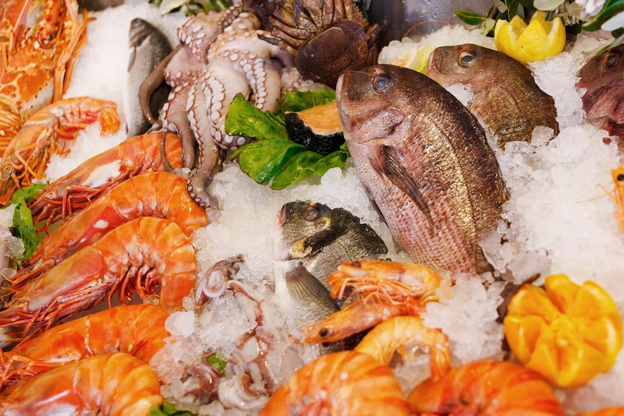 Un étal de poissons et crevettes frais présentés sur un lit de glace.