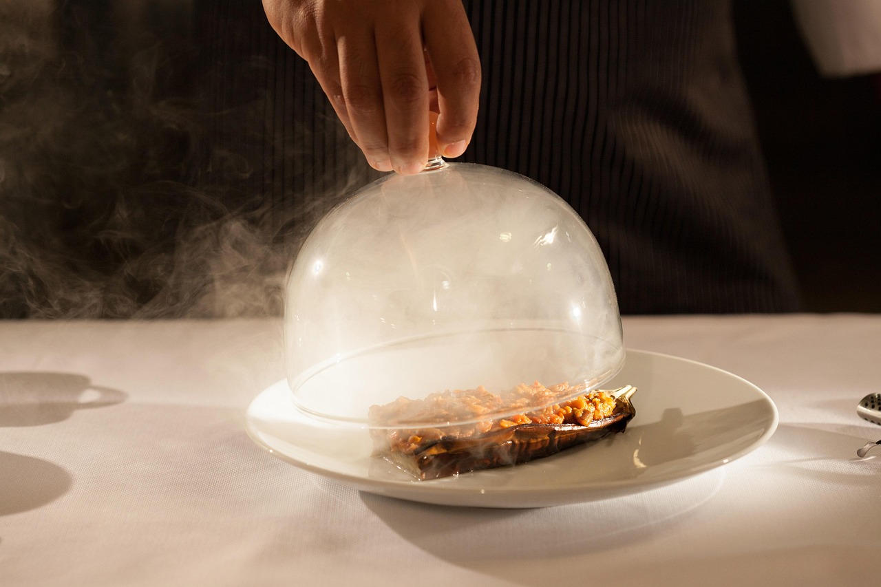 Présentation spectaculaire d'un plat d'aubergine fumée dans un restaurant gastronomique stambouliote.
