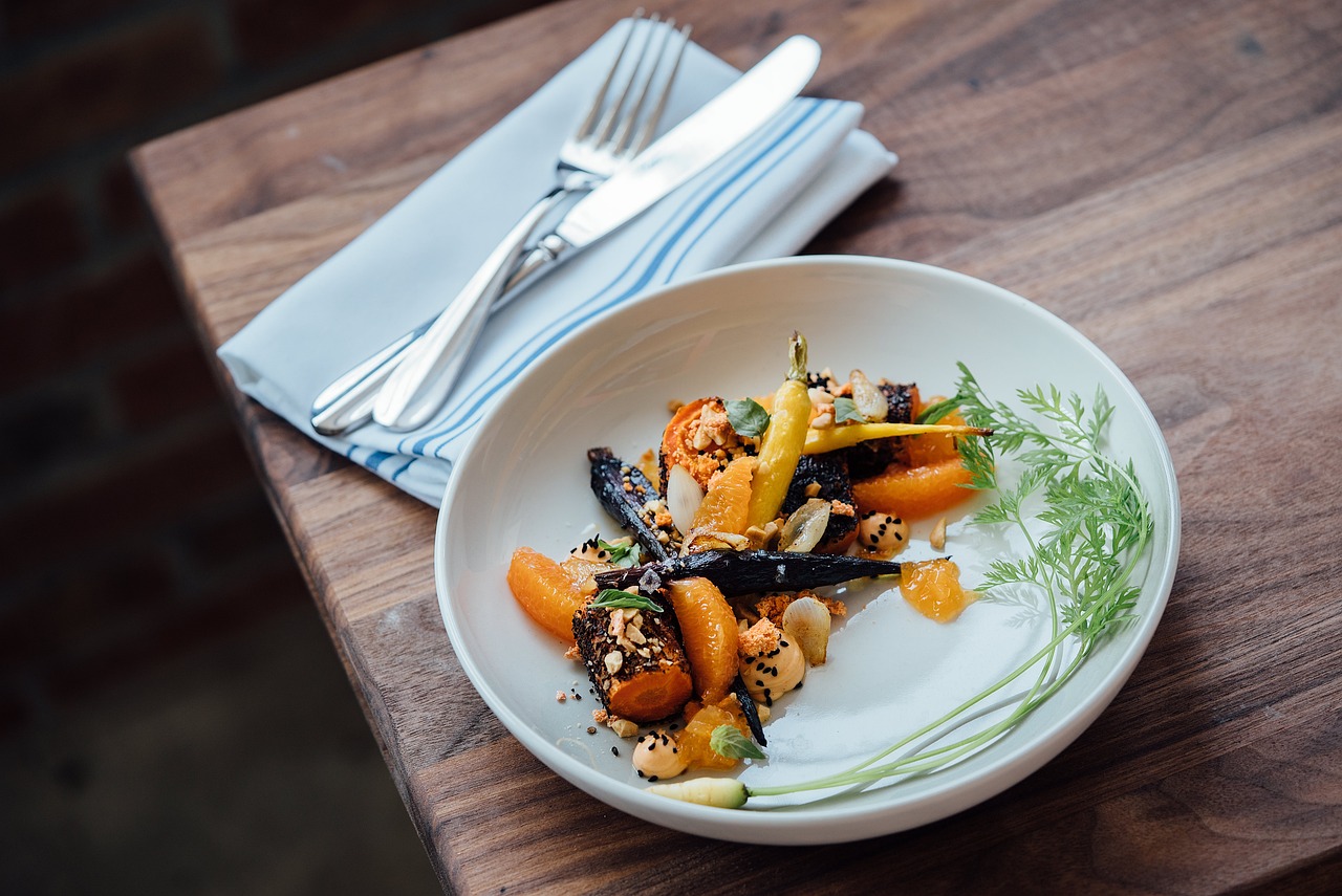 Assiette de légumes rôtis et agrumes avec une présentation gastronomique moderne.
