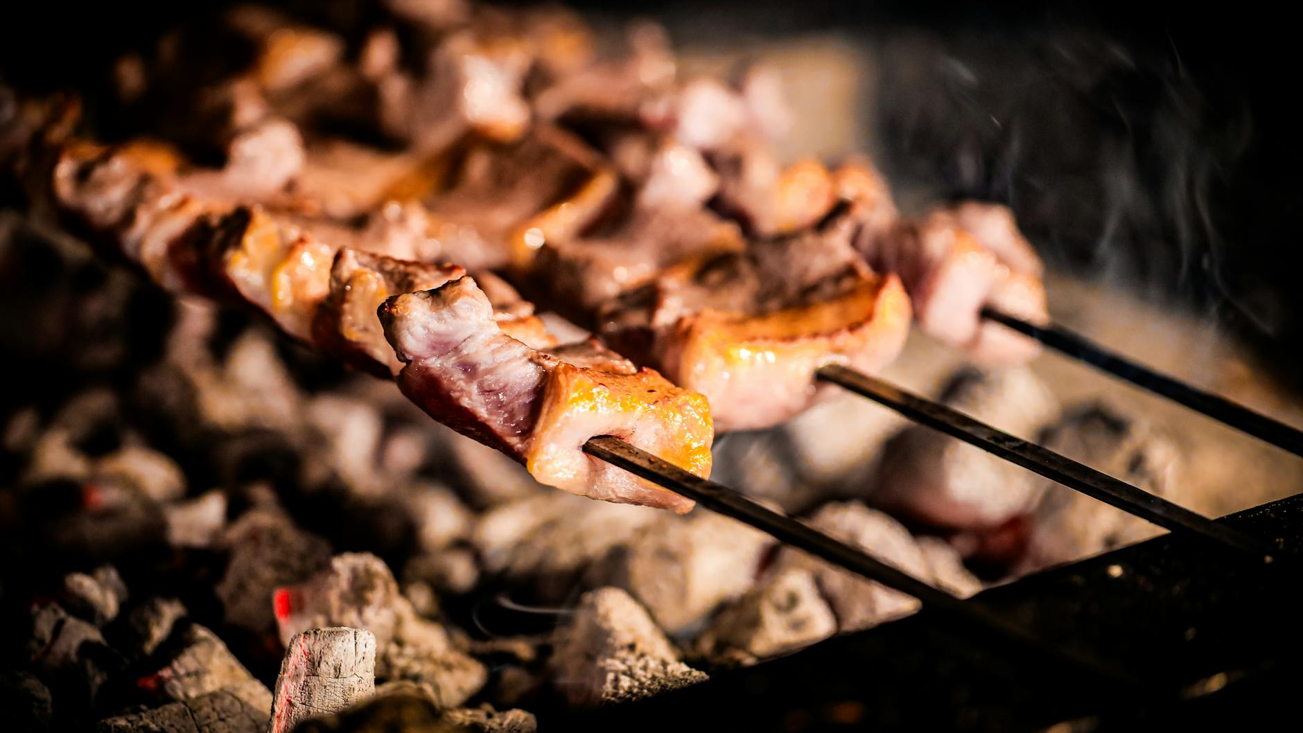 Gros plan de viande de Cağ Kebabı savoureuse cuisant sur un barbecue traditionnel.