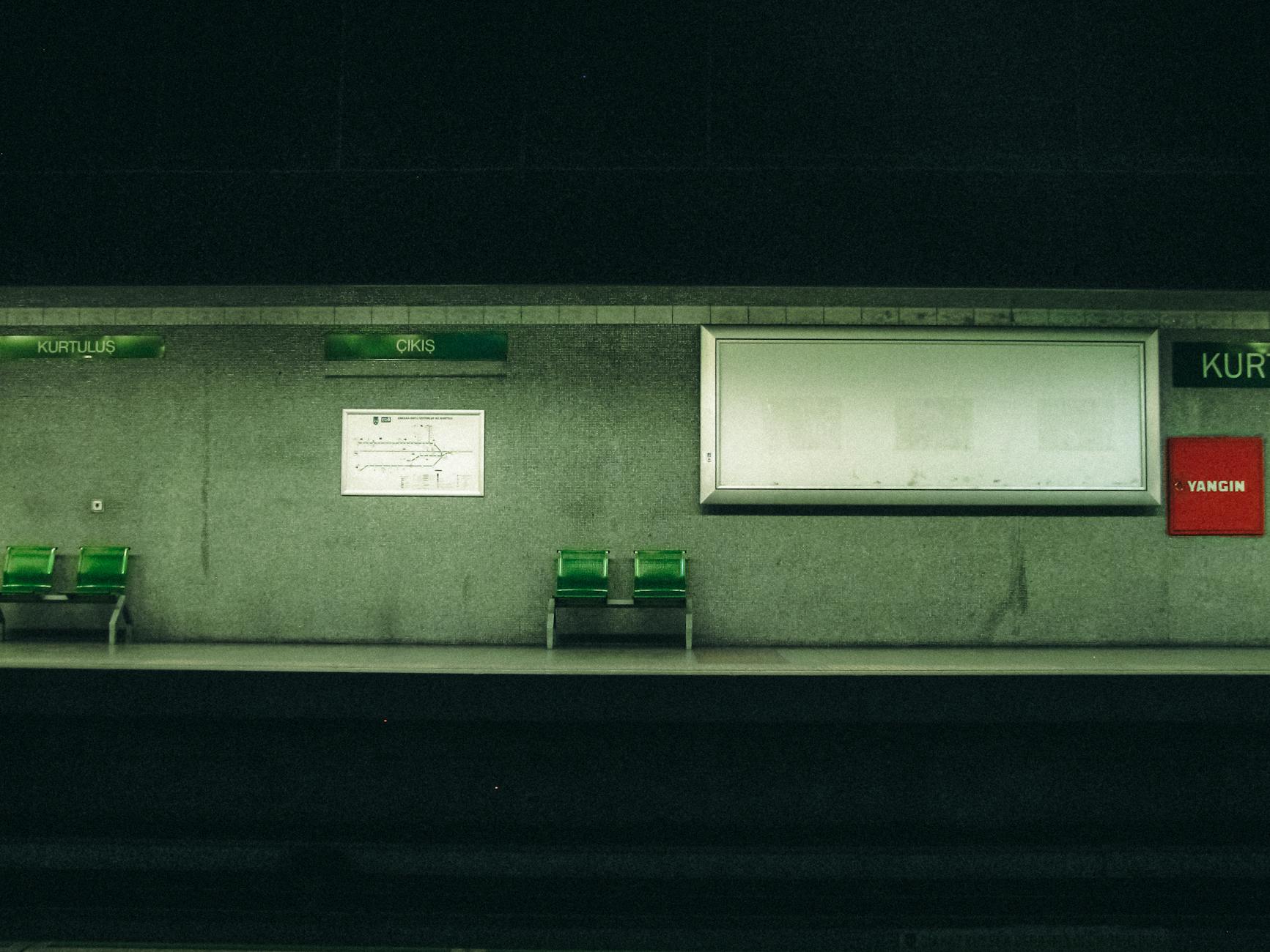 Quai de la station de métro Kurtuluş avec bancs verts et ambiance urbaine.
