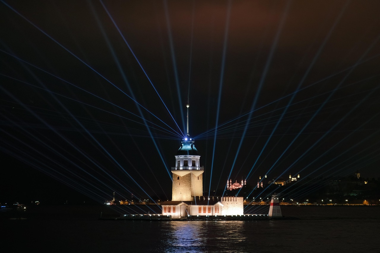 La tour de la Vierge illuminée dans la baie d'Üsküdar durant la nuit.