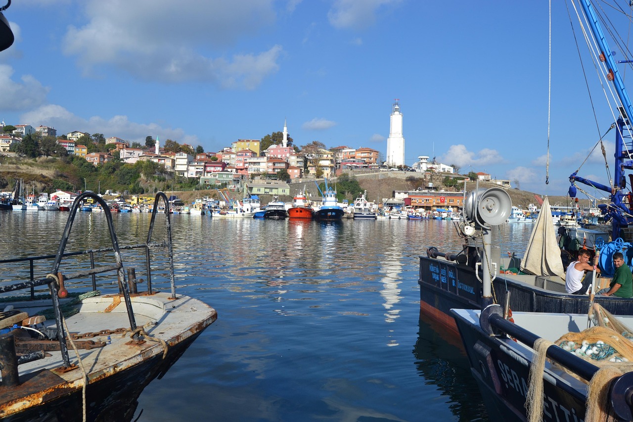 Bateaux de pêche colorés dans le port de Rumeli Feneri avec son phare.
