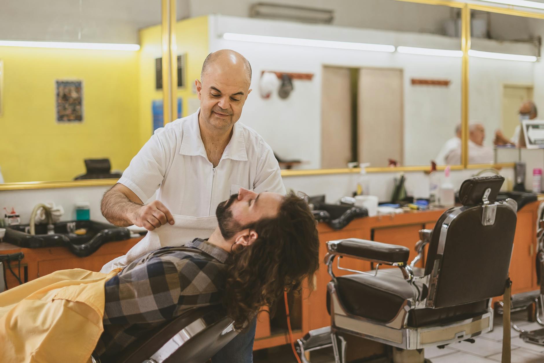 Un coiffeur traditionnel s'occupe d'un client dans un salon de quartier à Istanbul.