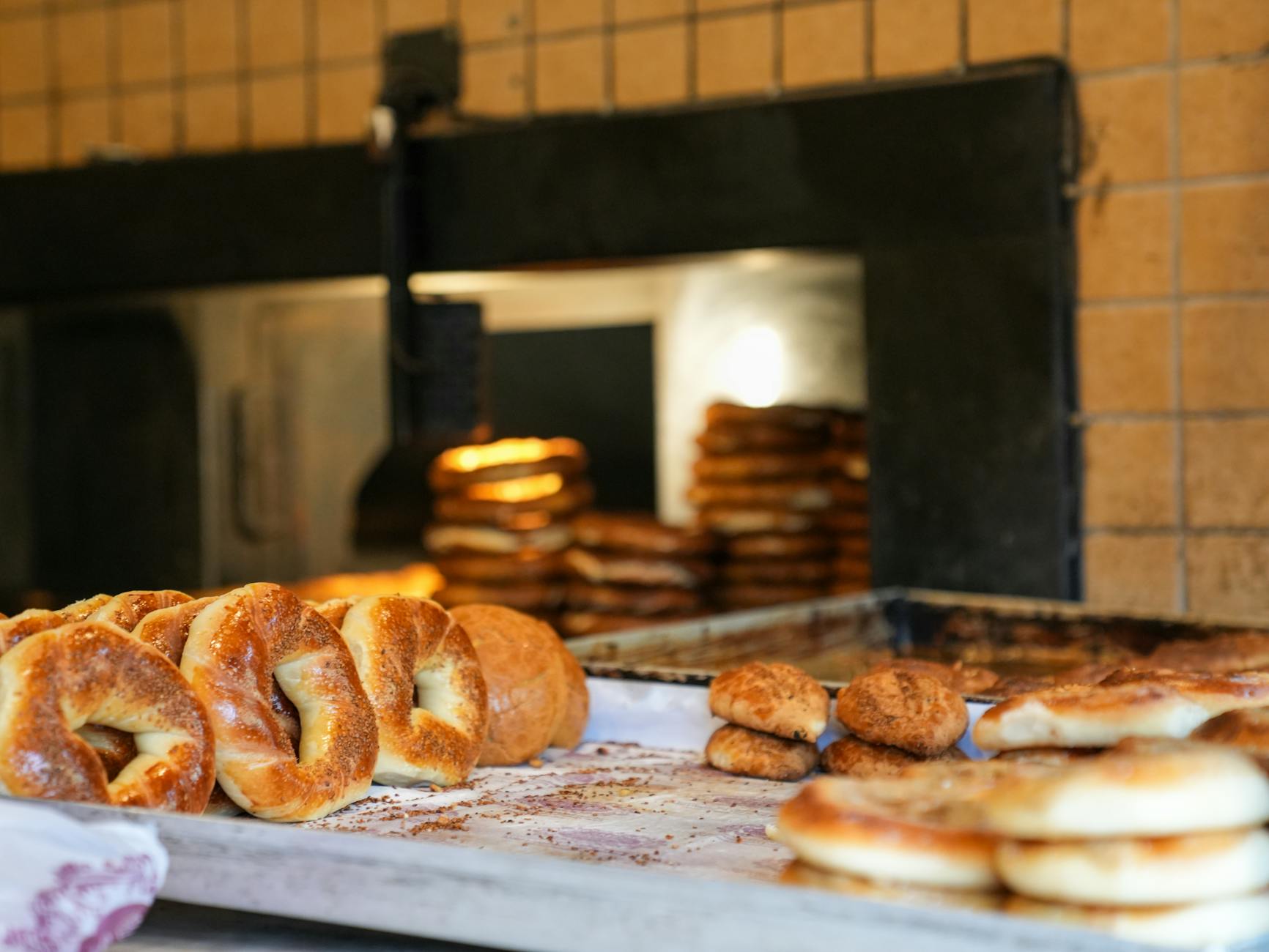 Simit croustillants et pâtisseries turques sortant d'un four à bois traditionnel.