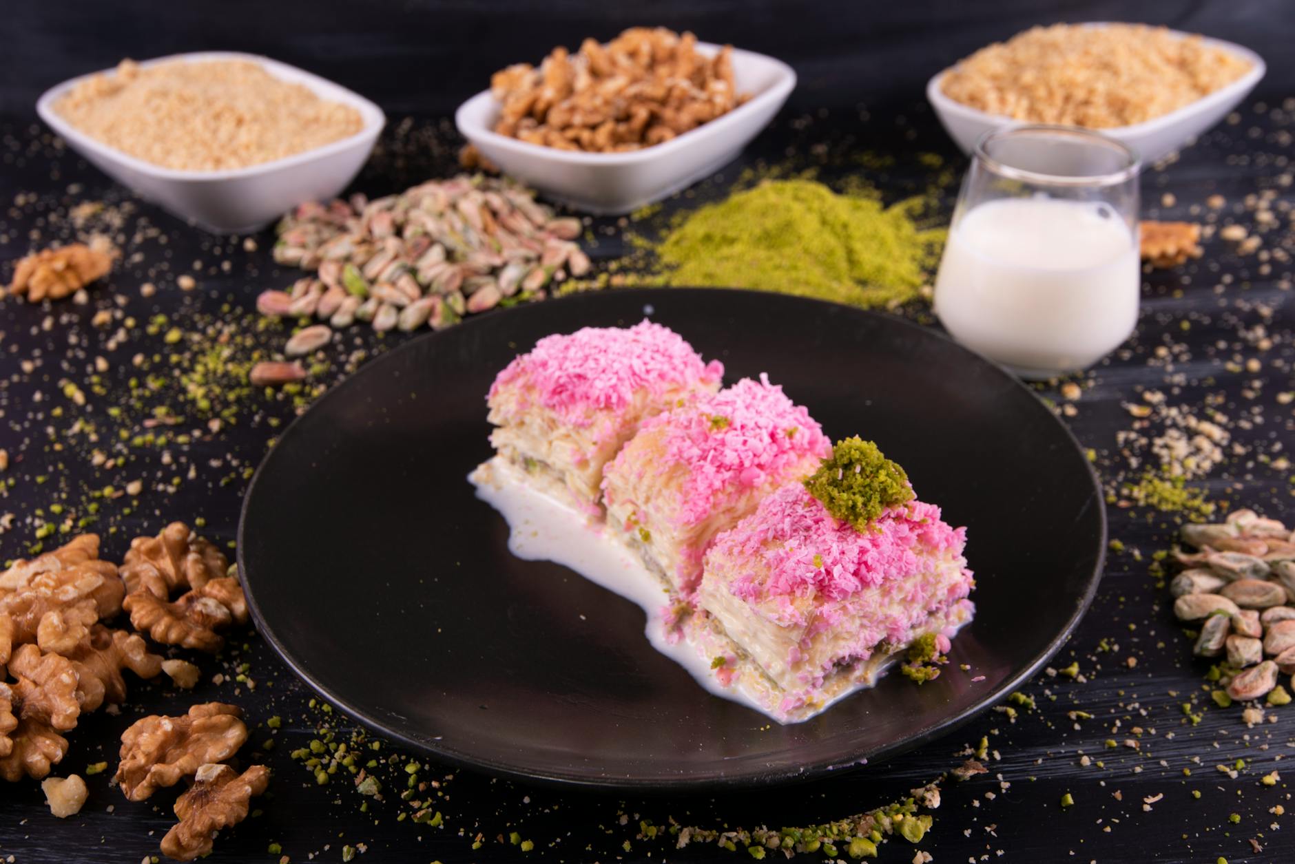 Trois parts de dessert turc au lait nappées de noix de coco rose.