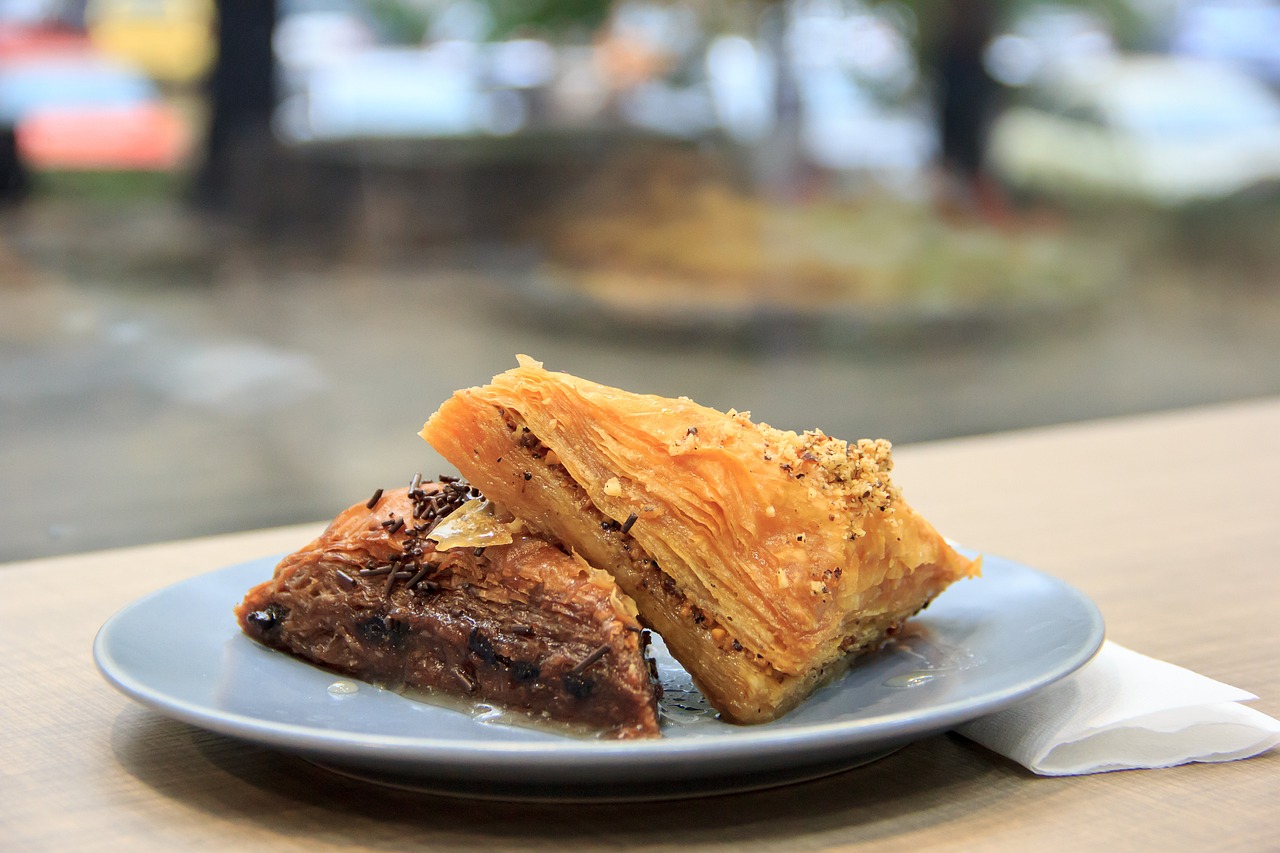 Deux parts de baklava croustillant sur une assiette bleue.