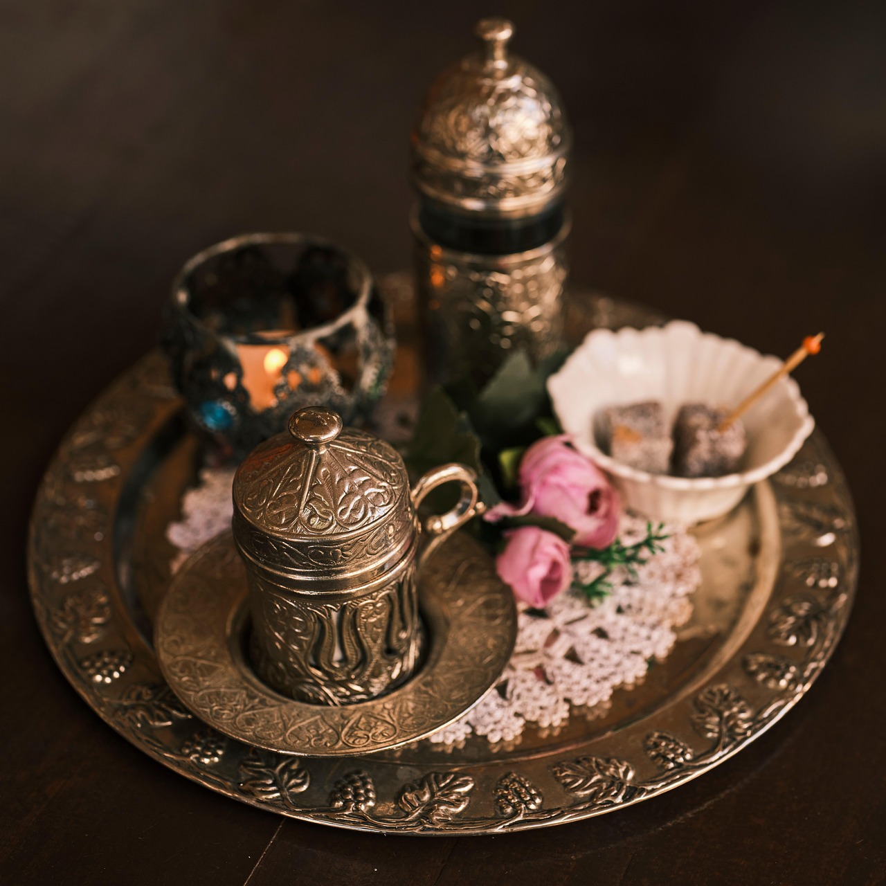 Service à café turc luxueux avec loukoums et décorations florales sur un plateau argenté.