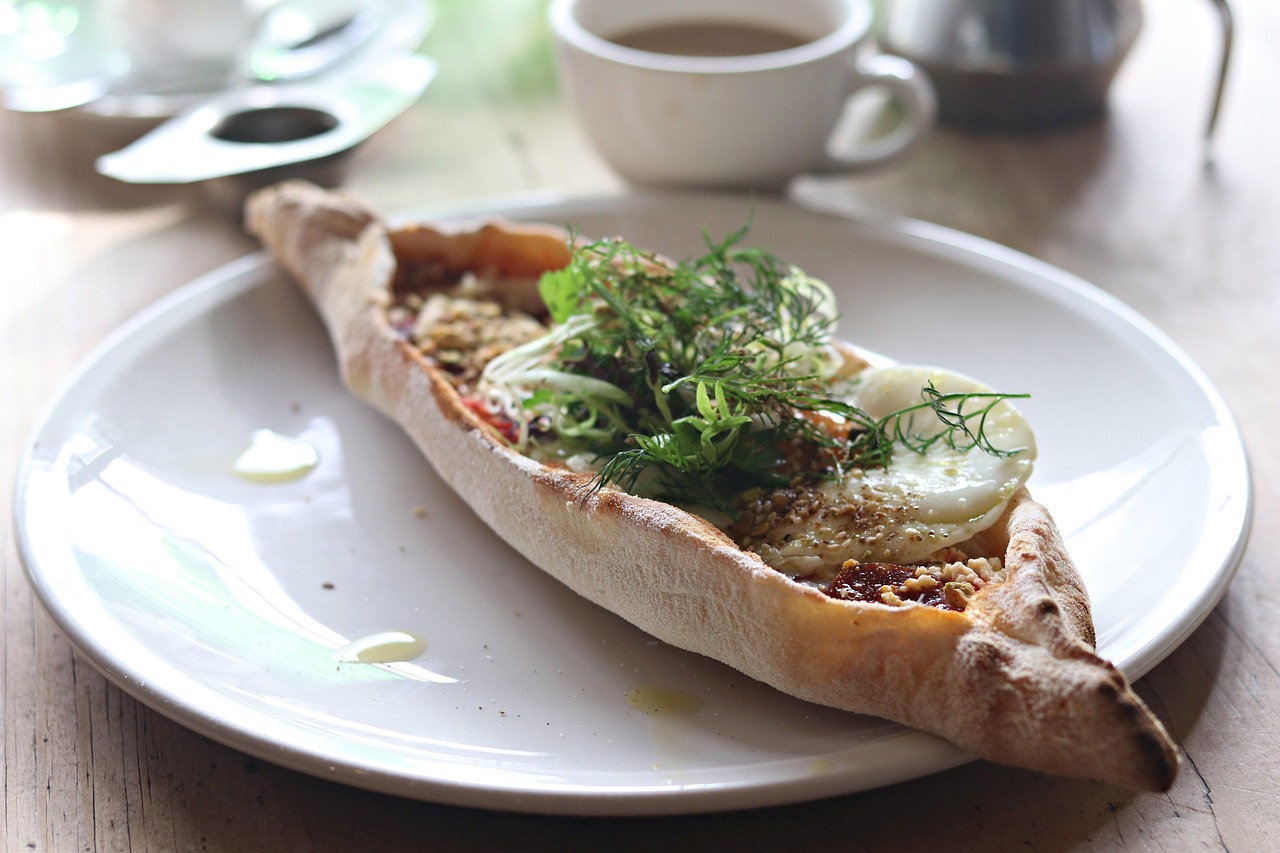 Un pide turc traditionnel garni d'œufs et d'herbes fraîches pour le petit-déjeuner.
