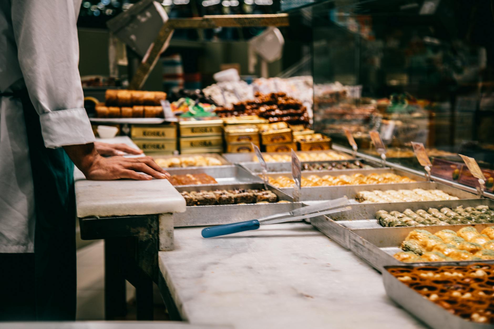 Différentes variétés de baklavas et pâtisseries orientales dans une vitrine éclairée.
